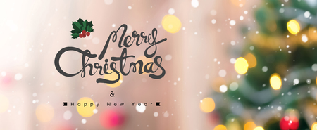 Merry Christmas and Happy New Year text on colorful bokeh background from decorated Christmas treeの写真素材