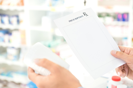 Pharmacist hand holding prescription checking medicine in drugstore (pharmacy)の写真素材