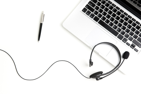 Microphone headset with notebook computer and pen on the table, top viewの写真素材