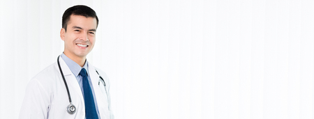 Smiling doctor on white vertical blind background - panoramic banner with copy spaceの写真素材