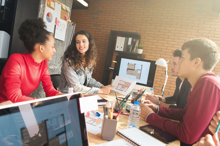 Young casual interracial creative team at the meeting of interior design company - teamwork and brainstorming conceptsの写真素材