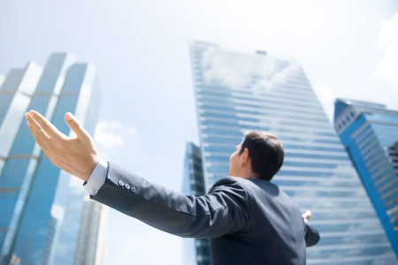 Businessman raising his arms, open palms, with face looking up to the sky - happy, success and achievement conceptsの写真素材