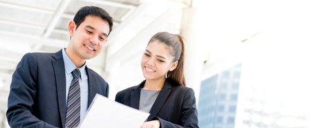Asian businessman and businesswoman discussing document, panoramic bannerの写真素材