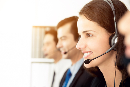 Smiling call center (or telemarketer) team working in the officeの写真素材