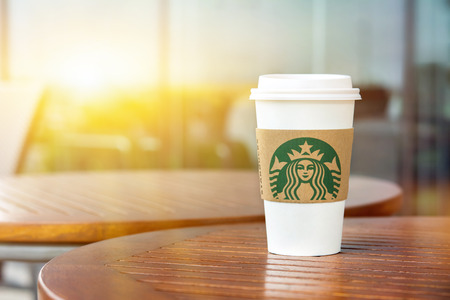 BANGKOK, THAILAND - JUN 29, 2016 : Starbucks take away coffee cup on wood table in Starbucks coffee shopのeditorial素材