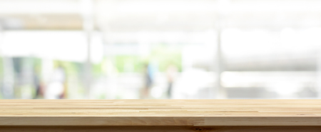 Wood table top on white blur abstract background from outdoor covered walkway in the city, panoramic banner - can be used for display or montage your productsの写真素材