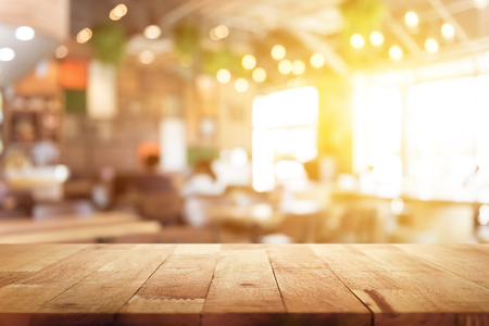 Wood table top on blur restaurant (cafe) interior background - can be used for display or montage your products (foods)の写真素材