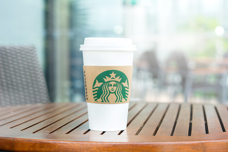 BANGKOK, THAILAND - JUN 29, 2016 : Starbucks take away coffee cup on wood table in Starbucks coffee shopのeditorial素材