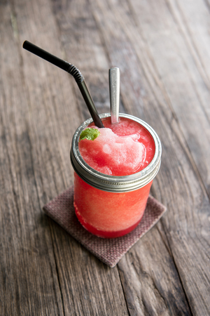 Red fruit smoothie drink on wood backgroundの写真素材