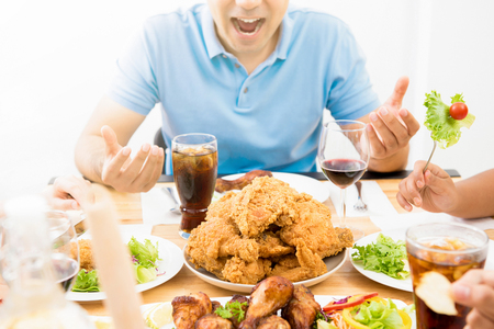 Food and drinks on dining table in front of excited hungry young manの写真素材