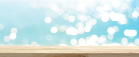 Wood table top on blue summer sparking sea water bokeh banner background - can be used for display or montage your productsの写真素材