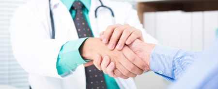 Doctor holding senior male patient hand with care - panoramic bannerの写真素材