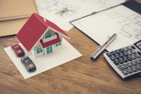 House model, blueprints and calculator on wooden table - real estate and property conceptの写真素材