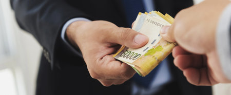 Businessman giving money, South Korean won banknotes, to his partner, bribery concept - panoramic...