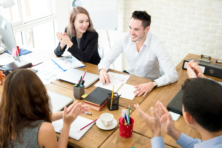 Business people giving their colleague the applause at the meeting in creative officeの写真素材