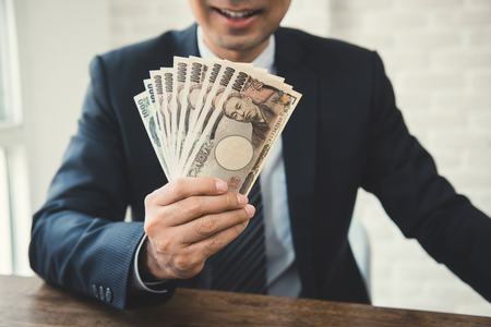 Businessman showing money, Japanese yen banknotesの写真素材