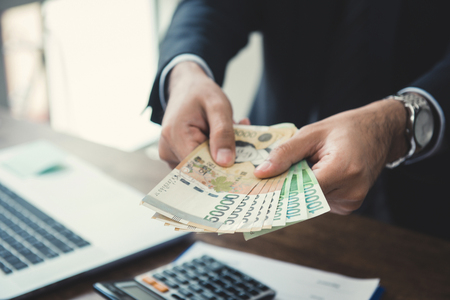 Businessman giving money, South Korean won billsの写真素材