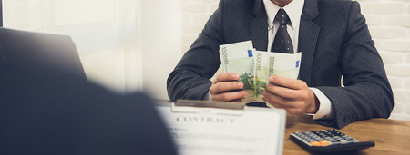 Businessman counting money, Euro banknotes, while making contract - panoramic bannerの写真素材
