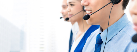 Call center agents talking on the phone to customers with a friendly and helpful attitude - panoramic banner with copy spaceの写真素材