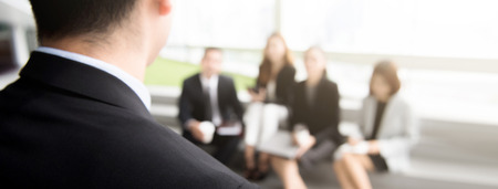 Back view of a businessman leader speaking to professional team audience in a meeting or seminar - panoramic bannerの写真素材