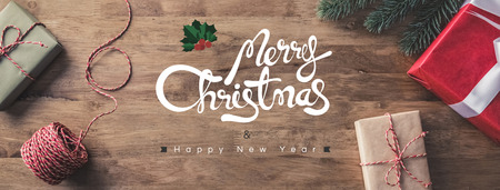 Gift boxes on a wooden table with Merry Christmas and Happy New Year greeting texts - horizontal web bannerの写真素材