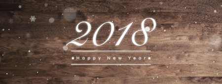 2018 Happy New Year greeting text on dark brown wood banner background with snow effectの写真素材
