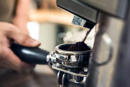 Automatic grinder machine grinding coffee beans into portafilter basketの写真素材