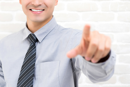 Smiling businessman hand touching on empty imaginary virtual screenの写真素材