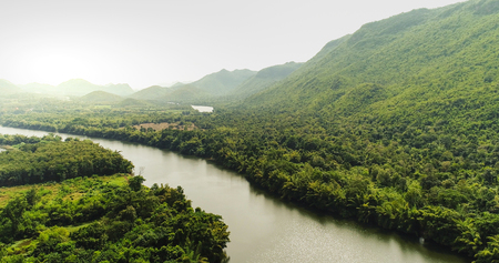 Beautiful natural scenery of river in southeast Asia tropical green forest  with mountains in background, aerial view drone shotの写真素材