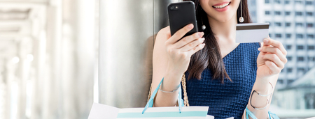 Woman shopping online and making payment digitally with credit card using mobile phone application, panoramic bannerの写真素材