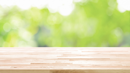 Wood table top on blur abstract natural green bokeh background - can be used for display or montage your productsの写真素材