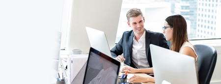 Happy business people coworkers working in office space on high rise building in the city, panoramic banner with copy spaceの写真素材