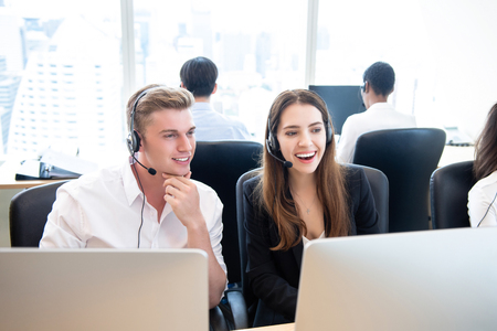Happy business people telemarketing team working together in call center headquarters office on high rise building in the cityの写真素材