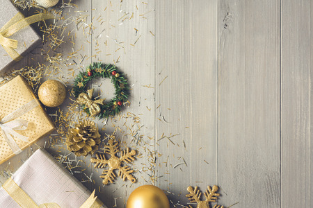 Silver and gold gift boxes and glittering Christmas decorating items on wood background top view with copy spaceの写真素材