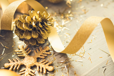 Golden curly ribbon with shimmer Christmas decorating items on wood backgroundの写真素材