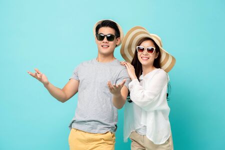 Happy Asian couple in summer beach casual clothes studio shot isolated on light blue backgroundの写真素材
