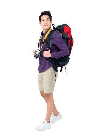 Isolated Portrait of handsome young attractive asian tourist man in casual attire carrying backpack and camera, studio shot white backgroundの写真素材