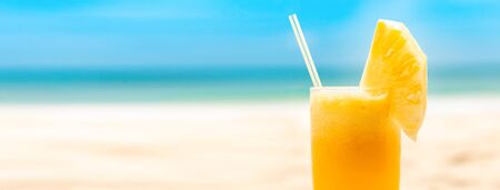 Refreshing tropical pineapple fruit juice smoothie drink in summer beach banner background with copy spaceの写真素材