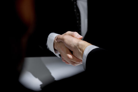 Anonymous business partners making handshake in confidential meeting