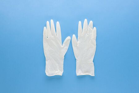 New clean medical rubber gloves for protecting hands from germs isolated on light blue backgroundの写真素材