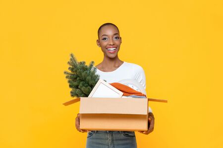 Happy smiling African American woman holding box moving stuff to the new houseの写真素材