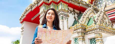 Banner picture of young Asian tourist woman backpacker solo traveling in ancient Thai temple during summer vacations in Bangkok Thailandの写真素材