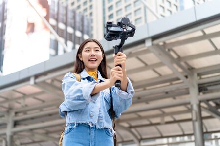 Smiling beautiful Asian woman tourist travel vlogger taking selfie video in the cityの写真素材