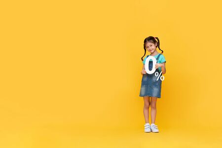 Cute little girl showing 0% number on yellow background with copy spaceの写真素材