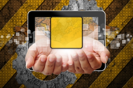 Hand woman pushing out of tablet-pc on industry backgroundの写真素材