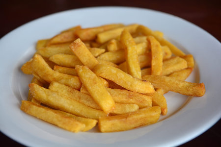 Fresh fried french fries on white plate