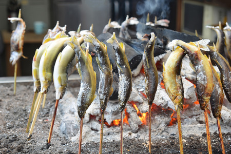 Fresh fish with salt being charcoal broiled, Japanese style BBQの写真素材