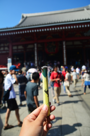 Woman hand holding incense sticksの写真素材