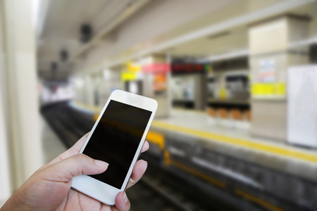 Closed up hand of man touch screen. Train station backgroundの写真素材
