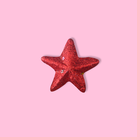 Red glitter shiny star on pink background for new year and christmas background, Minimal Conceptの写真素材